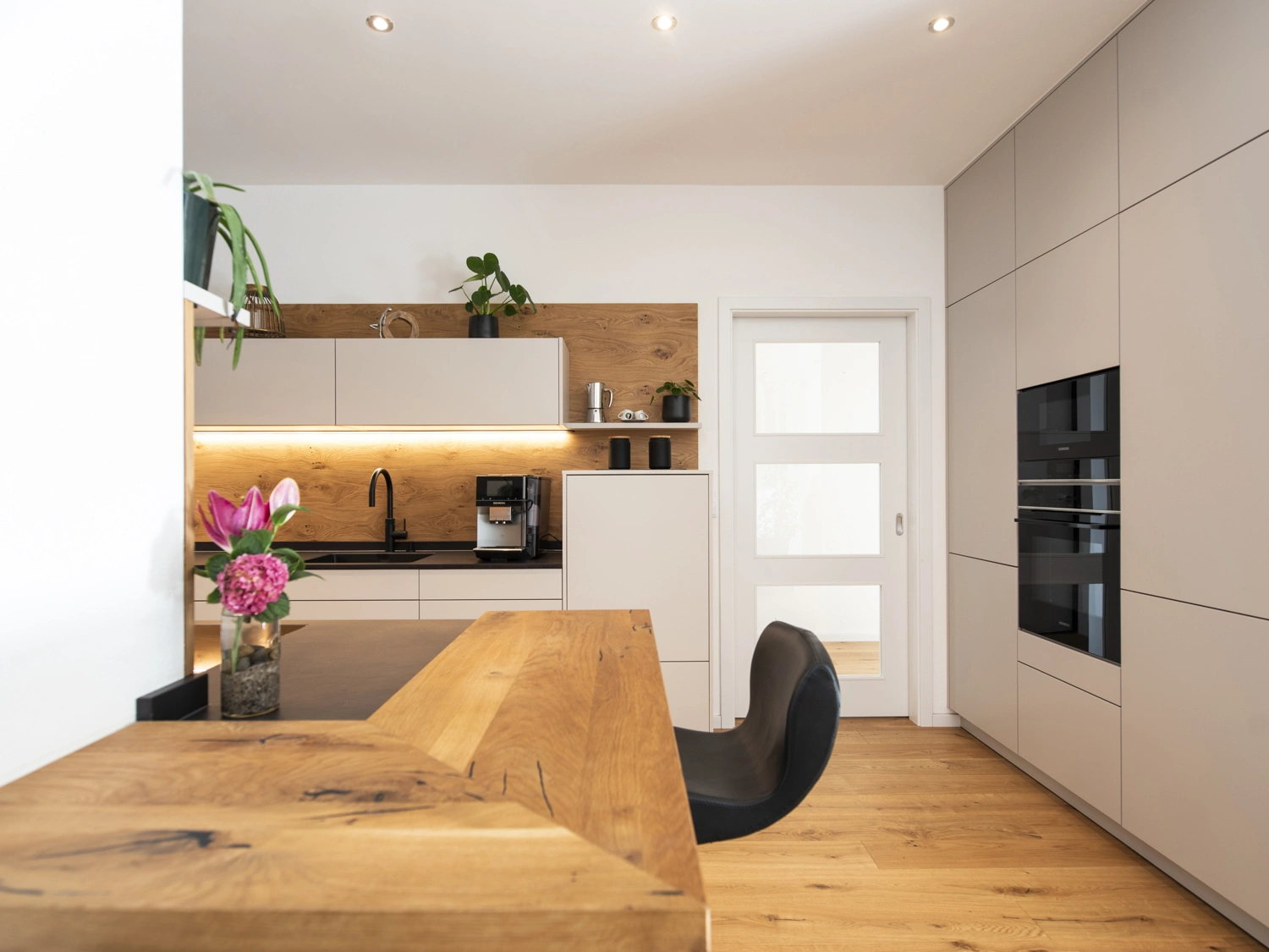 Thekenbereich mit Holzplatte und Blick in die Küche